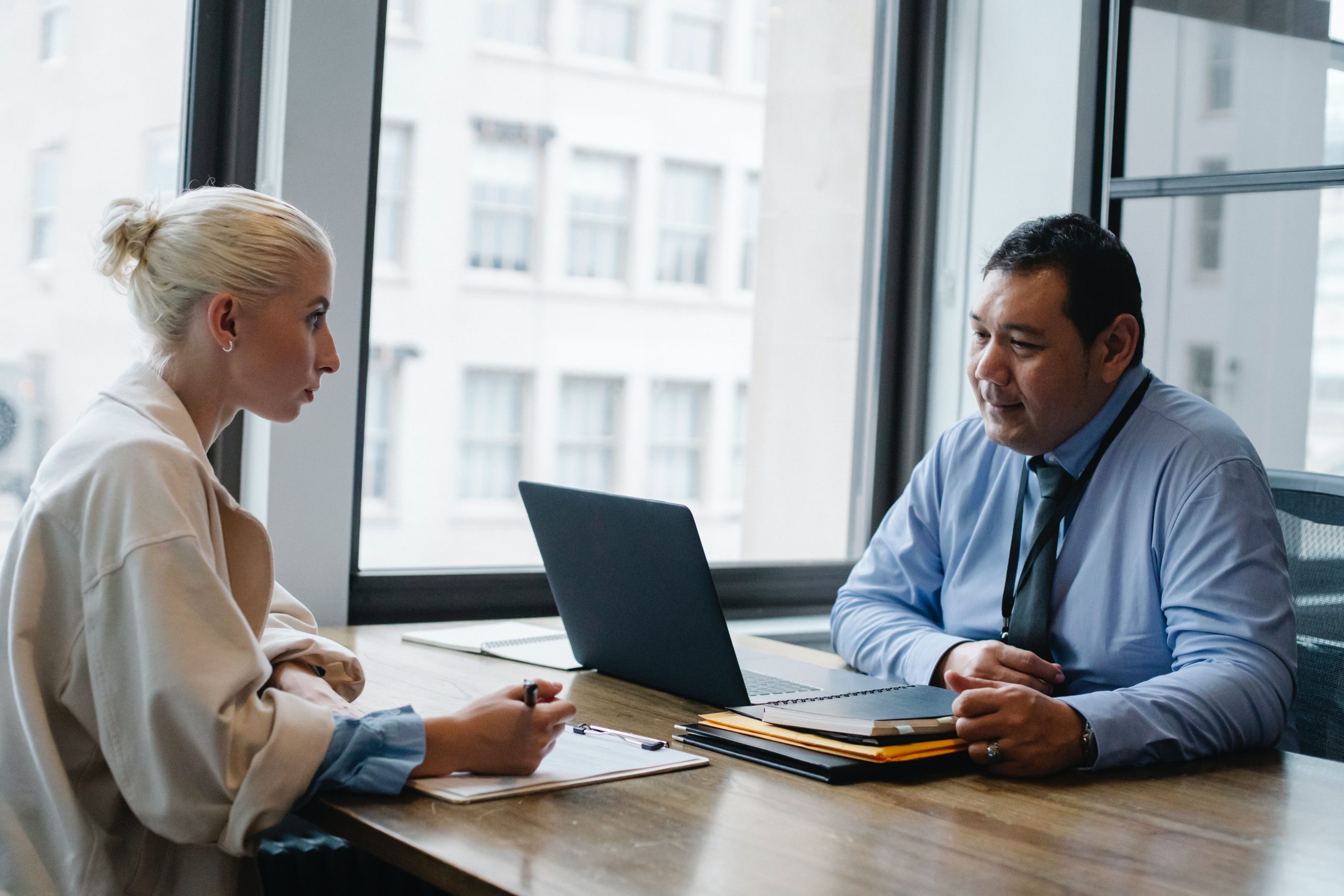 man sitting at laptop with woman opposite