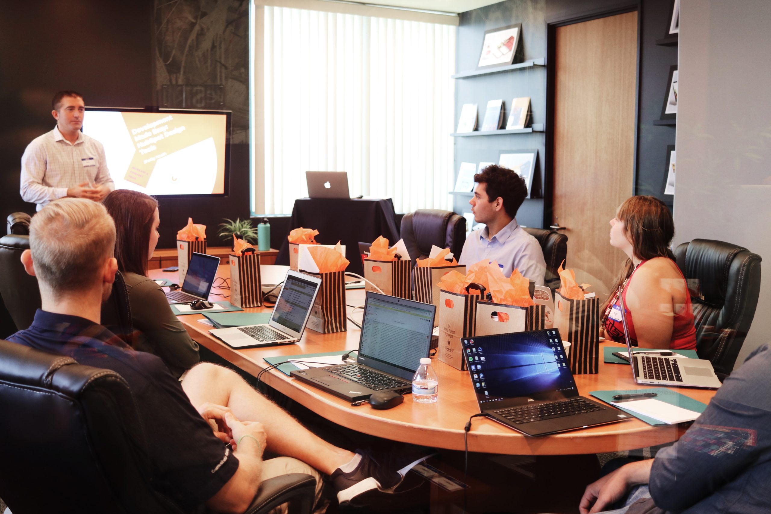 People meeting in a boardroom with laptop computers